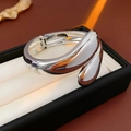 Macro di un bracciale in metallo argentato a goccia d'acqua in una scatola portagioie nera - Argento