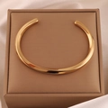 Bracelet jonc Mobius doré présenté dans un écrin de luxe en soie beige raffinée - Or