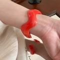 Close-up of a minimalist glossy red acrylic wave bangle worn on a model's wrist - 41# Bracelet-Red Glossy Wave
