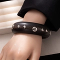 Detail view of a black wide wooden bracelet with polished silver metal rivets - Style L365-7 Black Mixed Size Round Studs