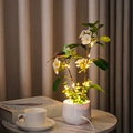 LED artificial flower bonsai with red bird and warm glowing lights on white ceramic base - Plum Blossom Green Leaf & Green Bird