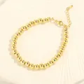 Primer plano de pulsera de cuentas doradas con cierre de langosta y cadena de extensión - 6mm / Dorado