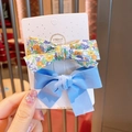 Two-piece hair clip set featuring a floral print and sky blue fabric bow on display card - Blue Floral & Solid Bow Set