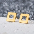 Detail view of 18K gold plated square hollow stud earrings on textured surface - Hollow Square / Gold