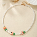 Detail of beaded pearl necklace featuring colorful tropical fish charms and gold clasp - White Pearl Orange Striped Fish