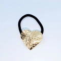 Detail of golden heart alloy hair tie with textured cross-hatch surface and black elastic band - Cross-Scored Heart Shape (Hair Tie 73)