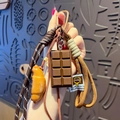 Creative pretzel keychain with chocolate and croissant charms on a woven strap - Pretzel-Croissant + Chocolate