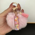 Detail of pink resin pendant with heart sequins, plush pompom and tassel keychain - Letter I
