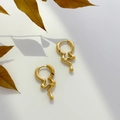 Close-up of golden abstract enamel hoop earrings with liquid lava metal texture - Lava Melt Style Earrings