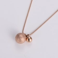 Dettaglio della collana in oro rosa con sfere opache e lucide su una catena a serpente - Oro rosa