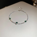 Vista macro detallada de la pulsera de plata con piedras de esmeralda verde brillantes - Plata/Verde