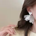 Gros plan de boucles d'oreilles cœur en résine blanche avec pétales en organza sur mannequin - 6# Tige en Argent - Fleur Lustrée