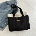 Fashionable black and white canvas tote bag with brown leather label for daily commute - Black