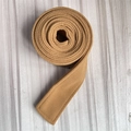 Close-up of camel wool belt with visible stitching for winter coats on wood background - Camel