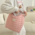 Detailed view of pink quilted heart tote bag with logo patch and woven handles - Heart Pink
