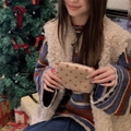 Close-up of plush beige sherpa pouch featuring red heart patterns and zipper closure - Lamb Wool Heart Rice Red