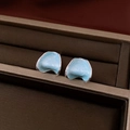 Vue macro détaillée de boucles d'oreilles fleur émail bleu clair en forme de C en coffret - Émail Courbe Irrégulier