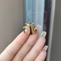 Ladybug beetle brooch in golden finish with sparkling brown rhinestones held by hand - Coffee