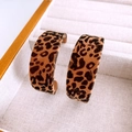 Macro view of leopard print flocking C-shape hoop earrings on a beige jewelry tray - Leopard Print Coffee (925 Sterling Silver Earring Post)