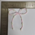 Accessoire nœud en perles rose et blanc avec règle en L pour mesurer la taille - Nœud en perles de rocaille rose clair n°3