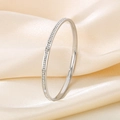 Macro shot of a thin silver titanium steel bangle with embedded zircons on silk fabric - 56*3.5mm / Steel