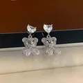 Macro shot of silver teddy bear earrings with heart-shaped zircon and pave crystals - White Zircon Silver (Silver Needle)