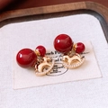 Dettaglio macro di orecchini a cavallo a dondolo placcati oro 18K con perline rosse - Rosso Vino/Oro (WE5290)