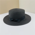 Dettaglio di un cappello boater in paglia nera con nastro di seta e fiocco coordinato - Nero