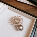 Dettaglio dell'elastico a spirale marrone con perla grigia su vassoio elegante - Elastico per capelli a spirale cavo telefonico con sfera in acrilico / Argento