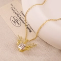 Golden stag antler necklace with central zircon pendant on a rustic linen background - XL1956 White Zircon Wings Deer Horn Gold