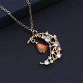 Macro d'un collier doré avec pendentif lune, étoile et cristal en forme de goutte - Dégradé Orange