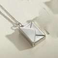 Makroaufnahme der silbernen Briefumschlag-Halskette mit feiner Kette auf hellem Grund - Silber Einfacher Stil