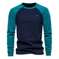 Detailed close-up of dark blue and teal raglan sleeves with embroidered chest logo - Navy Blue
