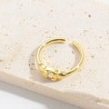 Detail of vintage gold open ring featuring a white zircon and woven texture on stone base - Single Round Zircon / Gold