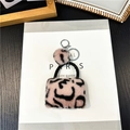 Portachiavi mini borsa di peluche con stampa leopardata rosa su un libro bianco - Rosa