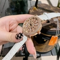 Luxury gold rotating flower watch with sparkling diamonds and white leather strap on wrist - White Strap with White Rhinestones