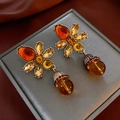 Macro shot of vintage amber flower drop earrings with rhinestones on gray display - Gold Bow Amber Stone Style (30#)