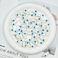 Detailed macro shot of white fish-shaped ceramic beads for DIY jewelry making and crafts - White