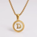Primer plano detallado de un collar dorado con colgante redondo de nácar blanco y la letra D - Letra D