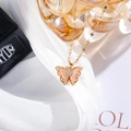 Detail of a gold butterfly necklace with pink translucent wings and white zircons on white silk - Rose Red