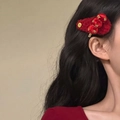 Detail of a plush red festive hair clip with gold accents on dark wavy hair - BB Clips / Single Piece / Red