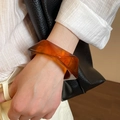Dettaglio di un bracciale in resina ambrata traslucida con sfaccettature geometriche - Stile 55 - Color Caffè