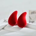 Red flocked teardrop stud earrings on white leather display for autumn winter fashion - Red
