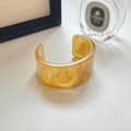 Detailweergave van een gele hars armband met ambertextuur in een lifestyle setting - Geel