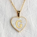 Golden heart necklace with shell inlay and letter G pendant on white linen background - Letter G / Gold