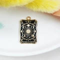 Golden tarot card pendant featuring The Wheel of Fortune design with black enamel - The Wheel of Fortune