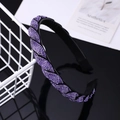 Twisted purple rhinestone headband with anti-slip teeth on a reflective black surface - Purple Rhinestone