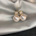Detail of vintage gold pearl earrings with shimmering crystals on smooth silk fabric - Gold Inlaid Zirconia Pearl (Silver Pin)