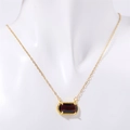 Dettaglio collana in oro con ciondolo rettangolare in gemma rossa su modello bianco - Viola (Marzo)
