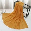 Detail of ginger yellow chiffon scarf draped on a rack with fashion accessories - 175cmx70cm / Turmeric